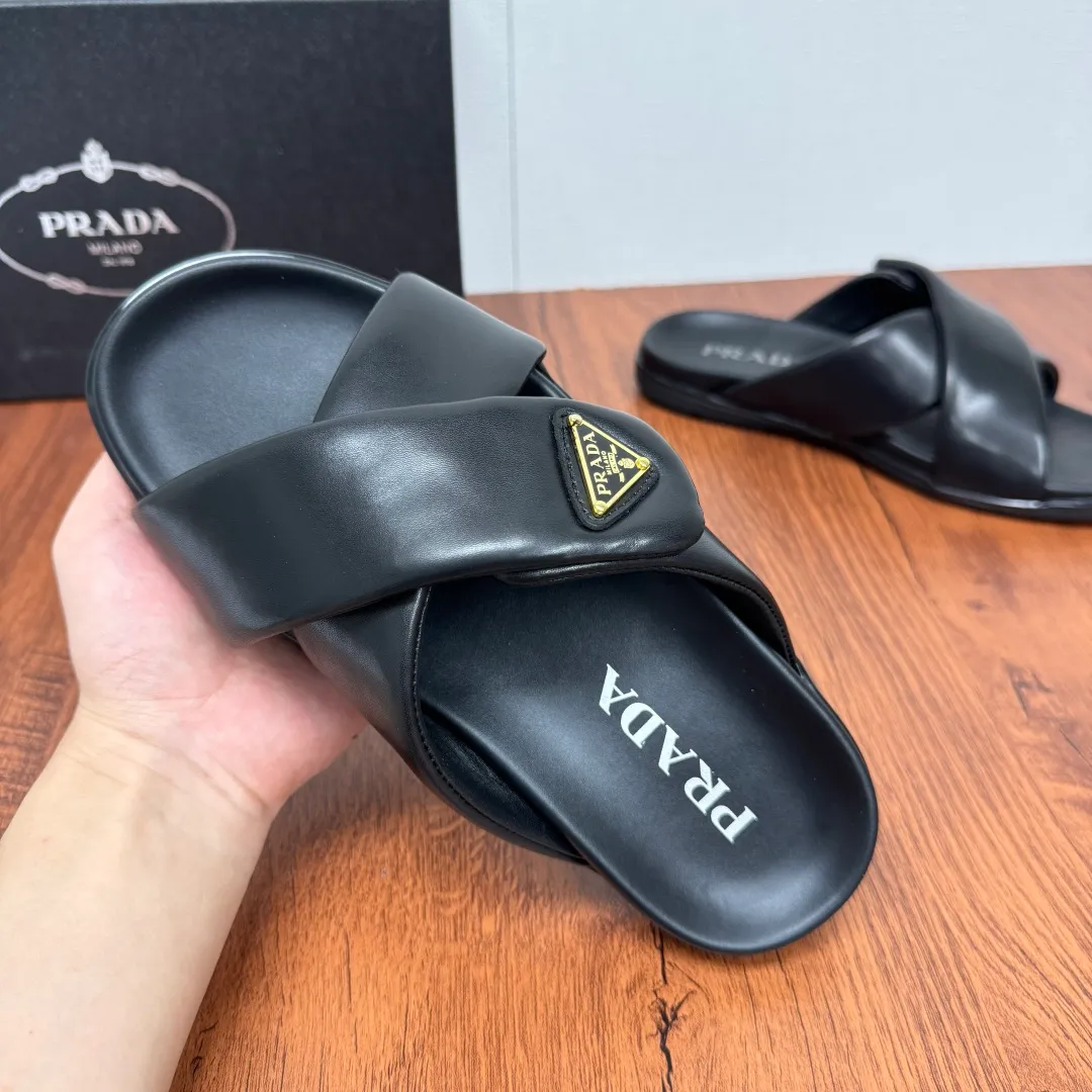Batch 580 Prada/Prada's new men's leather cross slippers. Velcro closure can finely adjust the size. Calf leather light luxury slippers. Thick soft calf leather wraps the upper. Fat but soft rubber lazy style, soft and comfortable, excellent foot feel. Genuine leather bottom layer, cross style, with a Velcro closure buckle, easy to adjust the appropriate size, and a perfect fit for the wearing experience. The enamel gold triangle logo highlights the brand's classic features. Lightweight rubber thin sole, high foot comfort! Complete package! Size: 39-40-41-42-43-44-45 Leather shoe size Item number: 2X7132 Black